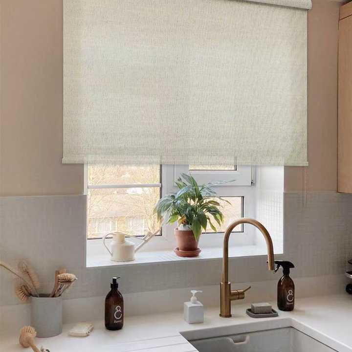 Beige roller blind over kitchen window
