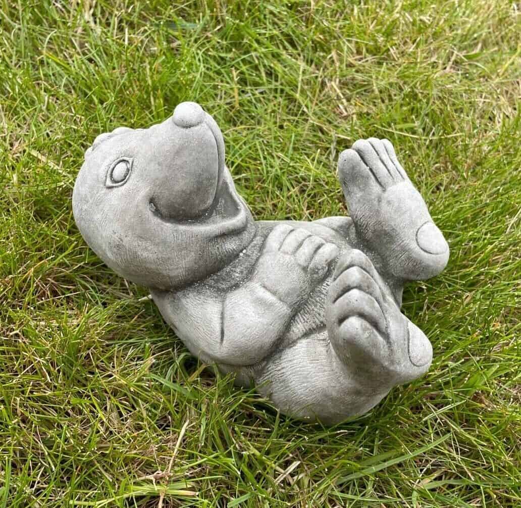 A happy mole laying on their back with feet up in the air. Laying in the grass of a British garden