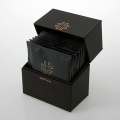 Black packaging box with multiple black packets inside, featuring a logo and brand name.