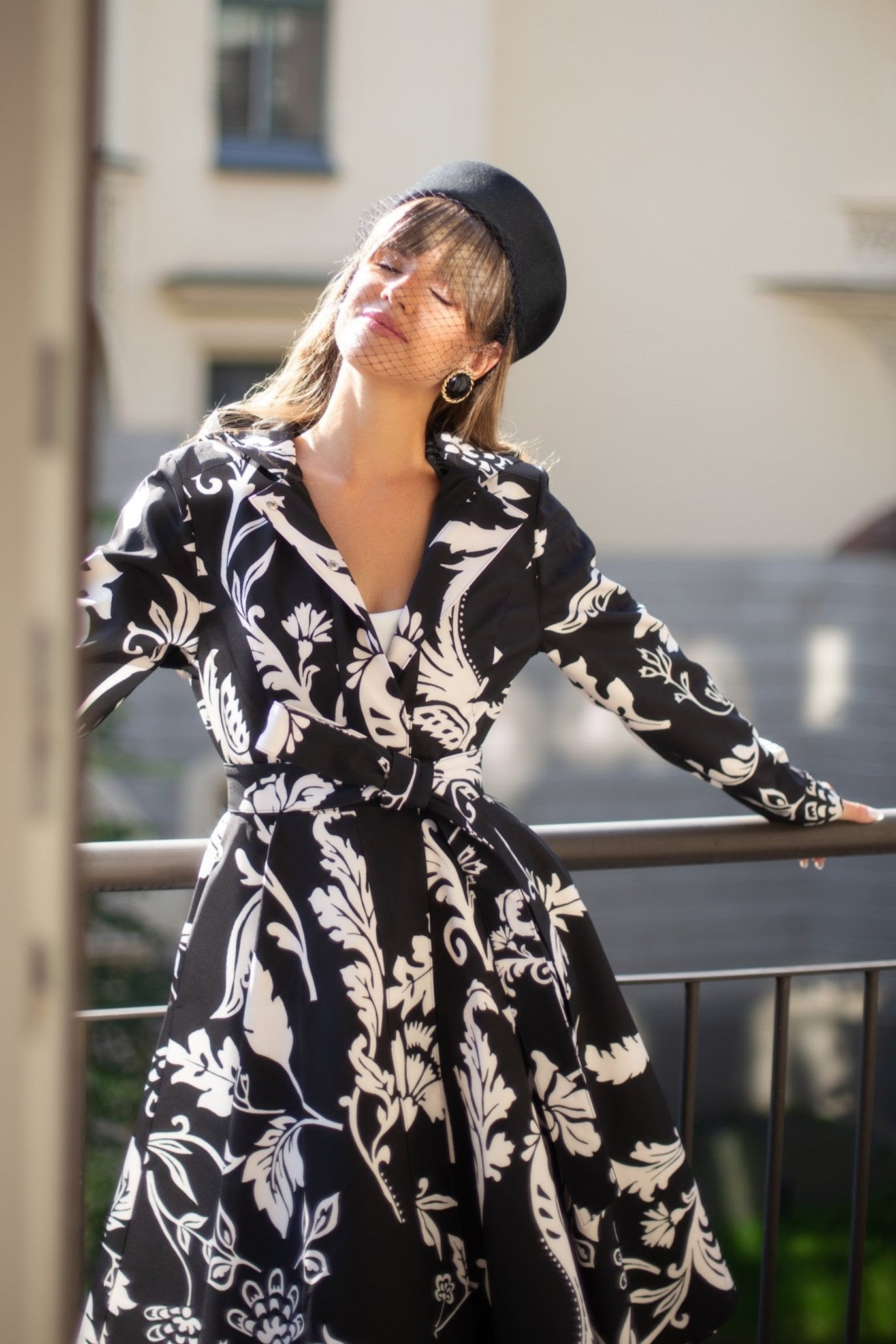 Woman wearing black floral trench coat styled for elegant city fashion outfit