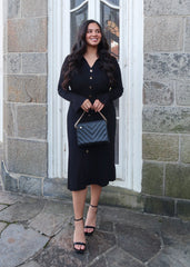 Black sweater dress, gold buttons, cuff sleeves, midi length, v-neck, collar