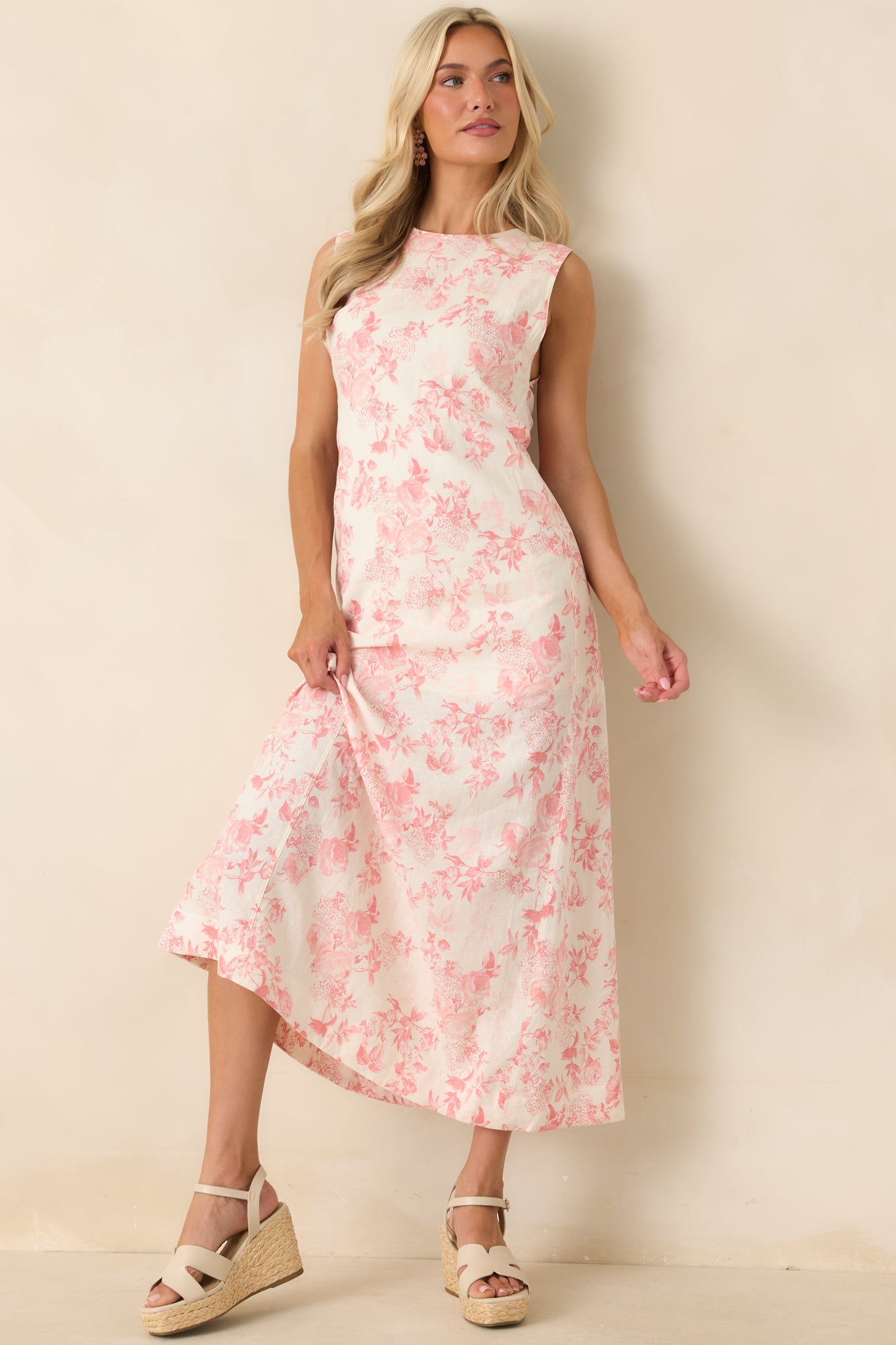 Ivory maxi dress with a romantic pink floral print, featuring a sleeveless bodice, round neckline, and a softly flowing silhouette that extends to maxi length.