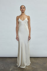 Front view of a bride wearing the ivory sueded silk charmeuse Kamperett Caroline Slip Dress, a maxi-length bias-cut bridal slip with V-neck and corded straps.