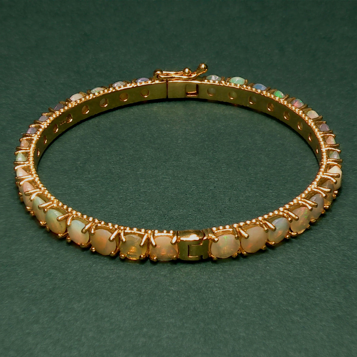 silver bracelet with gemstones on a green background