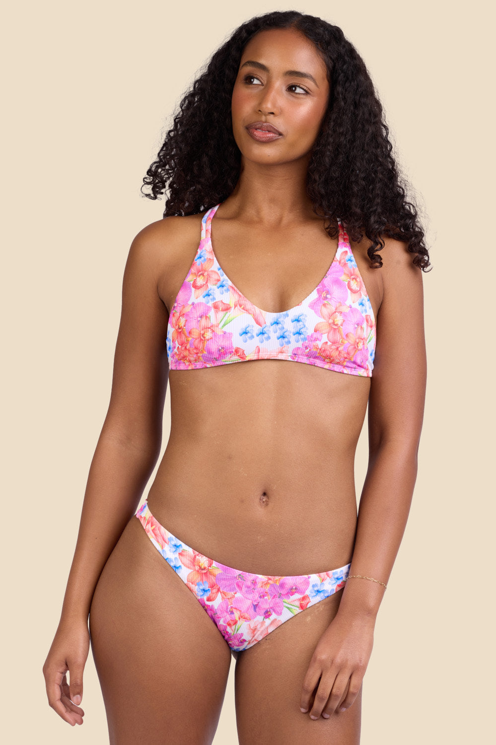 Female model wearing the Women's Kelia Bikini Bottom in the Orchids Ribbed print, standing in front of a yellow background shown from the front view

|| Size S, Hips 37"
