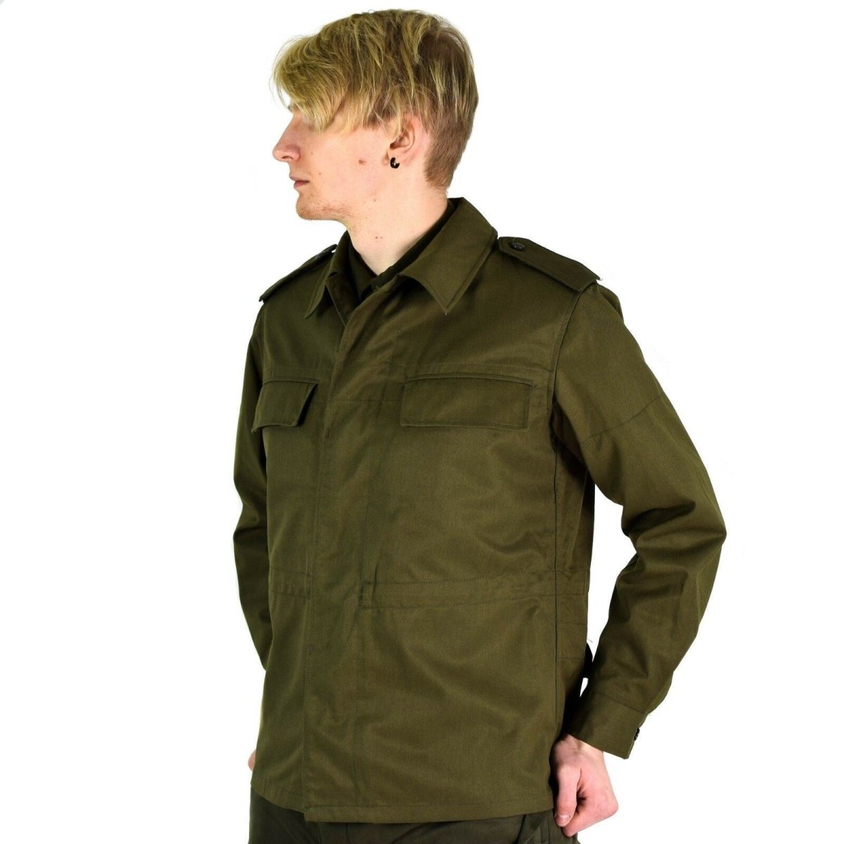 Man wearing an olive green vintage Czech M85 military field jacket with epaulets and chest pockets, facing left